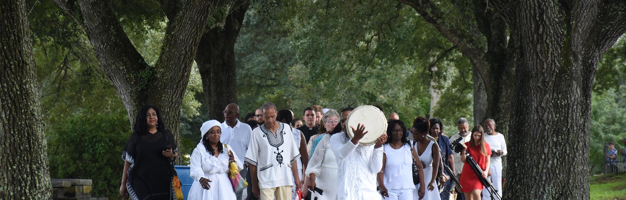 Descendants, RSCJ and guest process to the monuments in the cemetery adjacent to St. Charles Borromeo (By Linda K. Behrens)