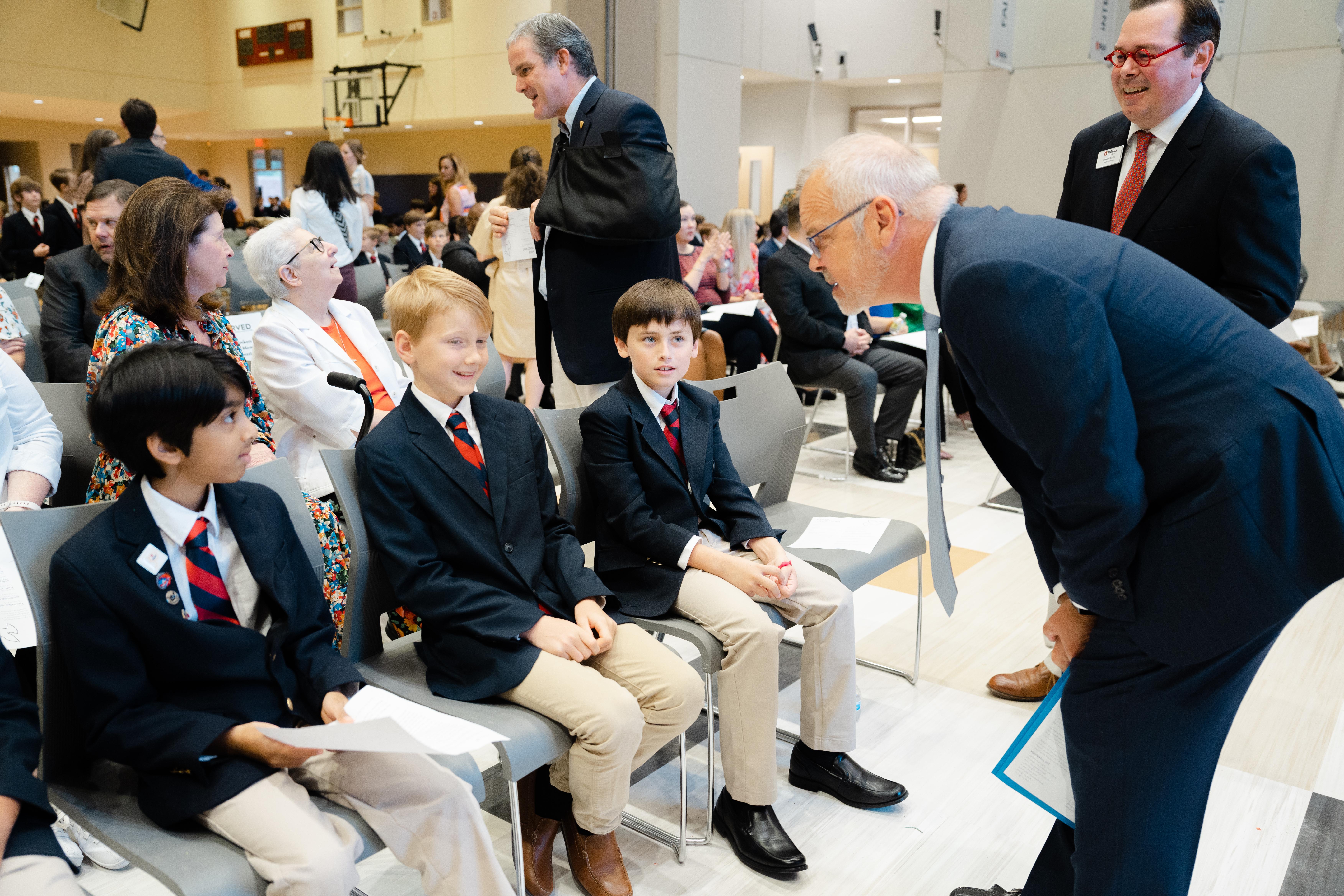Nat Wilburn and Steven R. Turner, Jr. (right) greet Regis students before Mass. (Photo courtesy of The Regis School of the Sacred Heart)