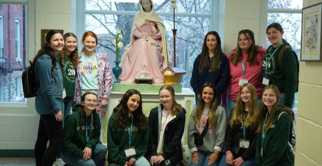 Students pose with the statue of Mater located at the Academy of the Sacred Heart in St. Charles