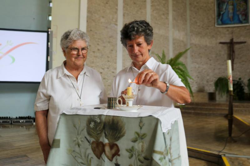 Claire Castaing, RSCJ (right), stands with current Superior General Barbara Dawson, RSCJ,  and lights Sophie's candle. This candle was at Sophie’s bedside at the time of her death; and the Society has kept it since then. Each new superior general, at the time of her election, lights this candle for a brief moment.